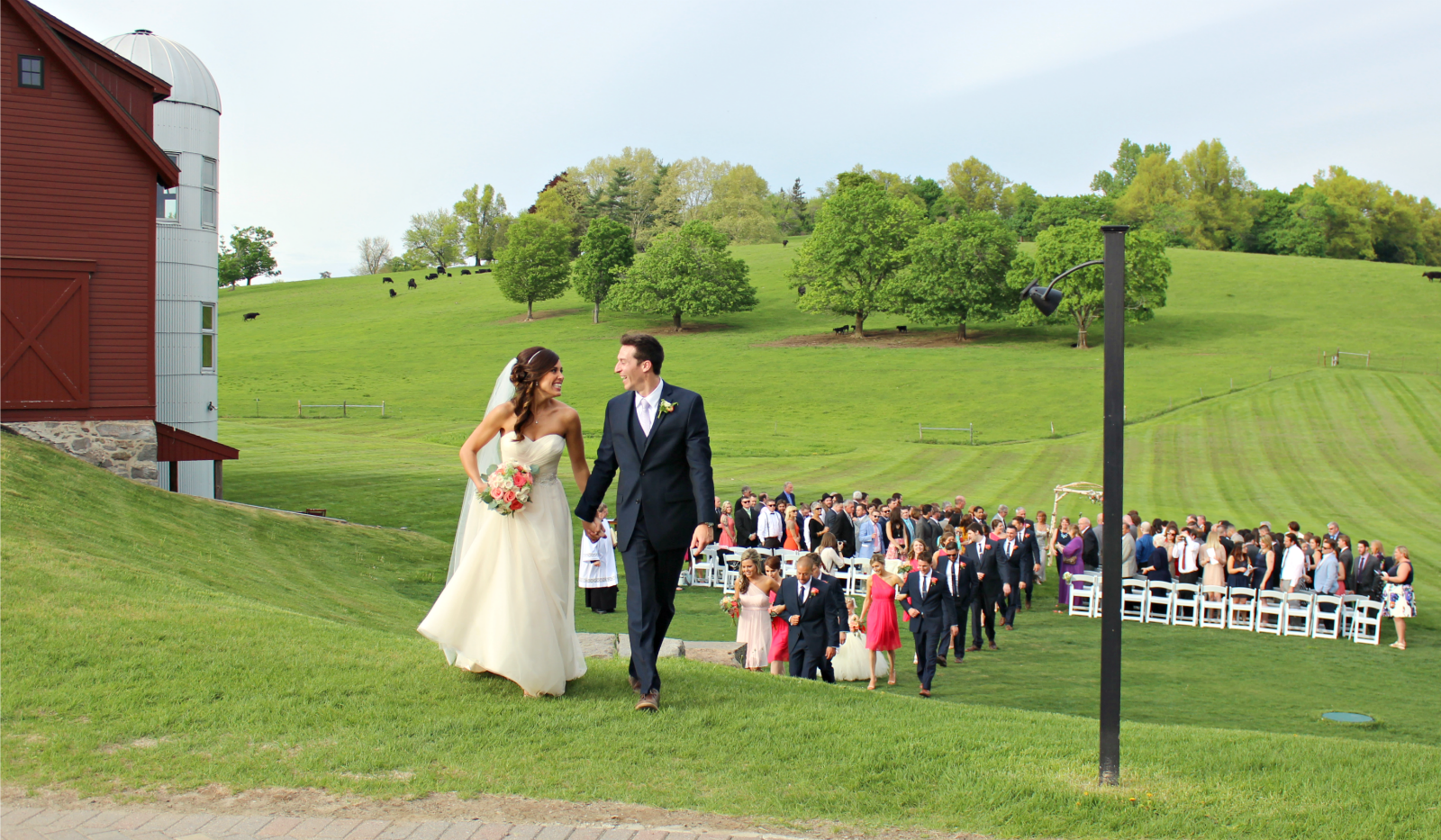 Bride and groom recessional with hill in the background 